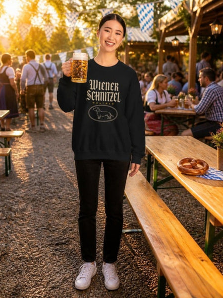Woman wearing the Wiener Schnitzel Weather crewneck, smiling and holding a beer stein in an Oktoberfest beer garden