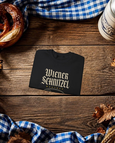Wiener Schnitzel Weather crewneck folded on a wooden table styled with a pretzel, beer stein, and Bavarian checkered cloth